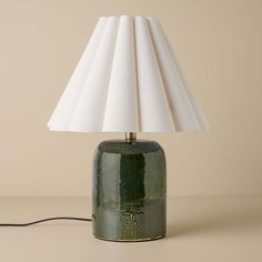 a green table lamp with a white shade