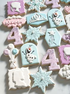 decorated cookies are arranged in the shape of numbers and snowflakes on a table