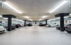 an empty parking garage with several cars parked in the space between it and another car