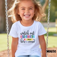 Gear up for the exciting journey ahead! Introducing our 'Watch out Kindergarten, Here I Come' custom name t-shirt, designed to make your little one's first day of school even more special. This back-to-school tee is perfect for capturing those unforgettable moments. Personalize it with your child's name and let them shine with confidence as they embark on this new chapter. Our unisex shirt for kids ensures a comfortable fit and is bound to become their favorite wardrobe staple. Get ready to celebrate this milestone with style Uplift any child's wardrobe with a custom kid's t-shirt. The Bella Canvas short sleeve tee for toddlers is a 100% Airlume combed and ring-spun cotton jersey with a tear-away label for extra comfort. Choose your favorite color out of a big variety, and make unique stap Personalized T-shirt For End Of School Year, Personalized Short Sleeve T-shirt For Back To School, Customizable T-shirt For Back To School Events, Name Print T-shirt For Daycare And Back To School, Back To School T-shirt With Name Print For Daycare, Name Print T-shirt For Daycare With School Spirit, Playful T-shirt With Name Print For School Year End, Personalized T-shirt For School's End Of Year, Personalized T-shirt For School Events At Year End