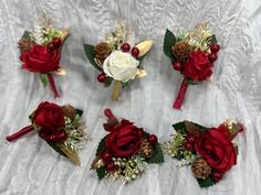 red and white boutonnieres with pine cones, berries and flowers on them