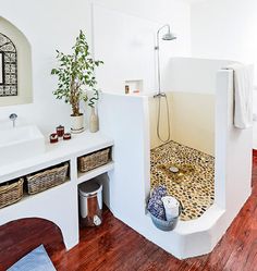 a bathroom with white walls and wooden floors