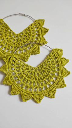 two crocheted hoop earrings on a white surface