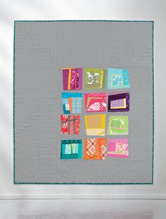 a quilted wall hanging on the side of a white wall