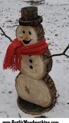 a snowman made out of wood with a red scarf around it's neck