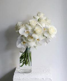 a vase filled with white flowers on top of a table