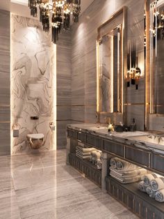 an elegant bathroom with chandelier and marble counter tops, along with two sinks