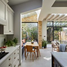 an open kitchen and dining room with large windows