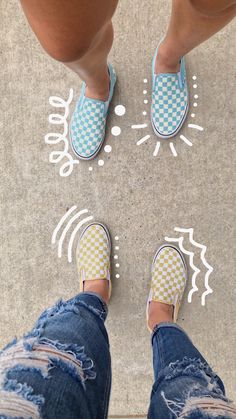 two people standing in front of a white and blue dotted design on the ground next to each other