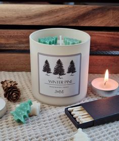 a white candle sitting on top of a table next to some candles and other items