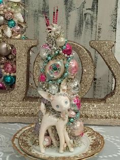 a white deer figurine sitting on top of a plate next to a christmas tree