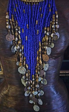 This ornately beaded bib statement necklace or chest piece features multiple beaded dangles consisting of purple, gold and silver beads all of which are suspended from a metal torc or torque. This torc is some sort of gold tone metal alloy which closes in the back with a chain and a small brass hook. The beads measure 13" at the longest point. This is a very comfortable and lightweight piece which is easy to wear. Unisex style for either men or women. Vintage. Presented by Kat Kouture. Gold Beaded Necklace For Festival, Bohemian Gold Beads For Festival, Festival Beaded Necklaces With Gold Beads, Bohemian Bib Necklace With Dangling Round Beads, Bohemian Bib Necklace With Dangling Beads, Bohemian Purple Beaded Necklaces With Large Beads, Bohemian Purple Beaded Necklace With Large Beads, Purple Bohemian Beads For Festival, Bohemian Bib Necklaces With Polished Beads For Festival