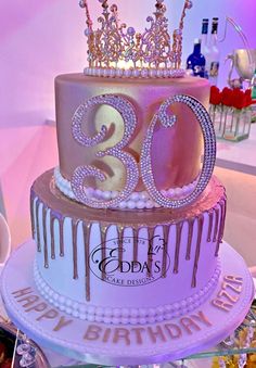 a 30th birthday cake decorated with pink icing and gold crown on the top tier