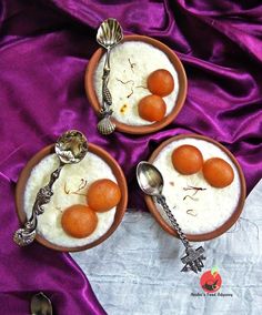 two bowls filled with rice and three orange eggs on top of each other next to spoons