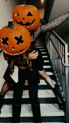 two women with pumpkins on their heads walking down the stairs in front of them