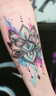 a woman's arm with a watercolor lotus tattoo on the left side of her body