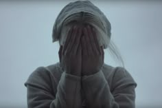 a woman covering her face with both hands