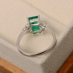 This ring features a 6*8mm emerald cut lab emerald and sterling silver finished with rhodium. Customization is available. It is made by hand, and it will take about 7 days to finish the ring after your payment is completed. Main stone: Lab emerald Main stone weight: Approx 1.40 ct Metal type: sterling silver finished with rhodium Accent stone: cz Customization is available, I also can make it with 14k solid gold (white or yellow or rose) and diamond accent stone, just feel free to contact me. An Promise Ring Emerald, Rectangle Ring, May Birthstone Rings, Oval Cut Ring, Ring Emerald, May Birthstone, Peridot Ring, Diamond Settings, Ring Promise