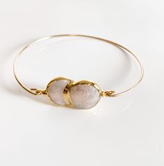 14k gold filled bangle with two beautiful gold freshwater pearls. Inside diameter is 2.25"–2.5" please measure around the widest part of your knuckles to ensure this will fit and slip onto your wrist. The closure is permanent. Gold Pearl Drop Bangle, Gold Pearl Drop Bangle Jewelry, Gold Stackable Pearl Bangle Bracelet, Gold Pearl Bangle As Gift, Gold Pearl Bangle For Gift, Gold Pearl Bangle Perfect As A Gift, Adjustable Gold Pearl Bangle Bracelet, Gold Pearl Bangle Cuff Bracelet, Adjustable Gold Pearl Bracelet