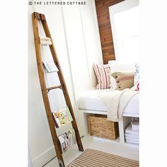 a ladder is leaning against the wall next to a bed with white sheets and pillows