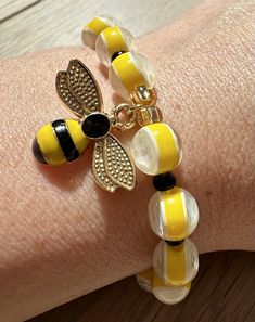 ✨PRODUCT DESCRIPTION The 'Bee Bumble' beaded bracelet from Beadbound Jewellery is a colourful wrist accessory and perfect for an apiarist or Bee lover 🐝 . Made by hand, the bracelet is made with alternating acrylic yellow and sparkly white round beads and black seed beads. It is finished with a beautiful Bee charm bead between 2 gold beads for added decoration. Please select your bracelet size when ordering. ✨PRODUCT CARE The beads are threaded onto elastic string so the bracelet will stretch t Bee Bracelet Diy, Seed Bead Bee Bracelet, Bee My Love Bracelet, Bumble Bee Bracelet, Honey Bee Bracelet, Wrist Accessories, Black Seed, Bee Charms, Gold Beads