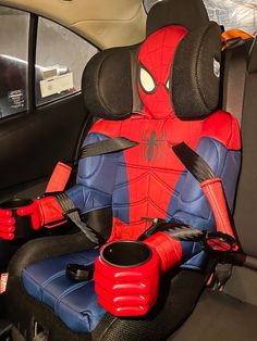 a spider - man costume is sitting in the back seat of a car, holding a cup