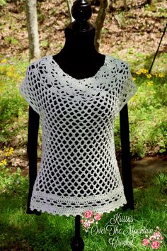 a white crocheted top on a black mannequin