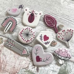 several decorated cookies sitting on top of a wooden table next to scissors and other decorations