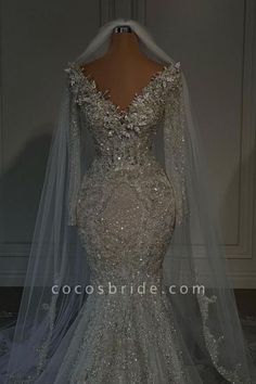 the back of a wedding dress with long sleeves and sequins on the shoulders