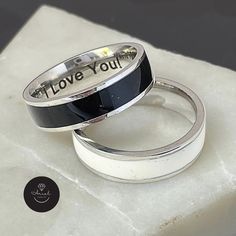 This stunning Personalized Tungsten Ring is truly a one-of-a-kind piece, featuring a Laser Engraved Secret Message that adds a special touch that uniquely expresses your love and appreciation. It makes for the Perfect Father's Day Gift for Dad, or for any gift-giving occasion. The Ring made from Best quality Stainless Steel and Available in two stylish Designs, choose between a sleek black with silver or an elegant white with silver finish. This ring is not only stylish and unique, but also carries a special message that will be cherished for years to come. Surprise your loved one with this meaningful and memorable gift today. ☻ STYLE: Men's Tungsten Ring ☻ MATERIALS: Stainless Steel ☻ RING WIDTH: 6mm / 0.25" ☻ THICKNESS: 1.5mm / 0.06" ☻ RING SIZE OPTIONS: (Us Size) 9,10,11 Silver Enamel Promise Ring, Gift Black Enamel Stainless Steel Jewelry, Engraved Enamel Anniversary Ring, White Engraved Ring With Polished Finish For Gift, Personalized White Sterling Silver Couple Rings, White Engraved Ring With Polished Finish As Gift, Black Enamel Ring For Anniversary, Customizable White Jewelry For Promise, White Gold Rings With Black Enamel For Gift