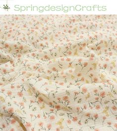 an unmade bedspread with pink and yellow flowers