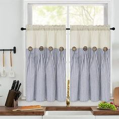 a kitchen window with blue and white striped curtains