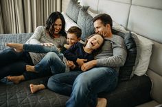 a family sitting on a bed laughing and having fun