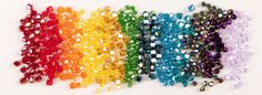 several colors of beads are arranged in a rainbow - hued pattern on a white background