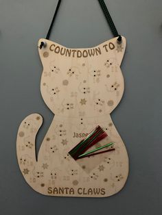 a wooden sign hanging from the side of a wall that says, countdown down to santa claws