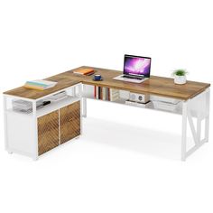 a computer desk with a laptop on top of it next to a book shelf and plant