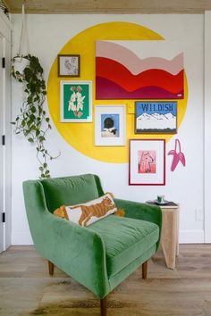 a green chair sitting in front of a wall with pictures on it