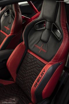 the interior of a sports car with red and black leather