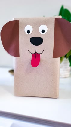 a brown paper bag with a dog's face cut out and tongue sticking out