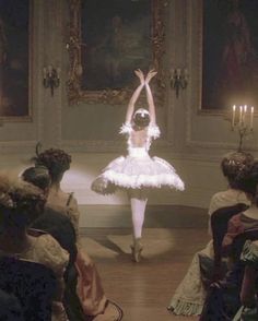 a young ballerina is dancing in front of an audience