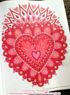 an adult coloring book with a heart on the cover and flowers in the middle, surrounded by hearts