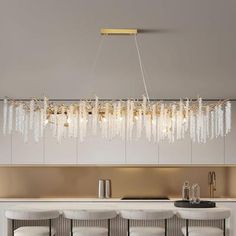 a chandelier hanging over a bar with white chairs