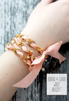 a woman's arm wearing a pink ribbon and gold chain bracelet