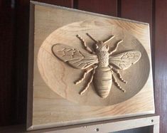 a wooden plaque with a bee carved on it