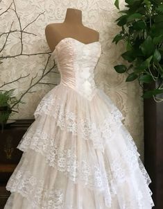 a white wedding dress is displayed on a mannequin