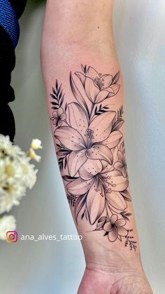 a black and white flower tattoo on the arm