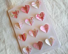 paper hearts are placed on top of a piece of white paper with pink and red designs