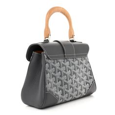 This is an authentic GOYARD Goyardine Mini Saigon in Grey. This stylish handbag is crafted of gray coated canvas with the classic Goyard chevron monogram print. The bag features a wooden top handle, silver hardware, an optional, adjustable leather shoulder strap, and gray leather trim. The crossover flap opens to a lemon yellow leather interior with a patch pocket. Grey Coat, Monogram Prints, Gray Leather, Wooden Tops, Yellow Leather, Lemon Yellow, Grey Leather, Leather Interior, Leather Trim