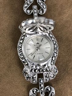 Vintage Stunning 1950's Bucherer Ladies Wrist Swiss Peak-A-Boo Watch from .800 Swiss Euro Silver and Marcasite Settings with Safety Chain This beautiful ladies wristwatch is in Excellent vintage condition. All the stones are intact, it winds and runs. It's extra nice 6.25 inches in length 3/4 inch diameter Silver Case Rare in this running condition shipping included The mineral marcasite, sometimes called white iron pyrite, is iron sulfide with orthorhombic crystal structure. It is physically an Vintage Jewelry And Watches With Diamond Hour Markers, Timeless Collectible Jewelry With Round Dial, Vintage Diamond Watch With Round Dial For Formal Occasions, Antique Silver Diamond Watch, Vintage Diamond Watch For Formal Occasions, Silver Art Deco Watches For Weddings, Art Deco Silver Wedding Watches, Vintage Watches With Polished Finish For Evening, Vintage Diamond Watch With Diamond Hour Markers For Evening