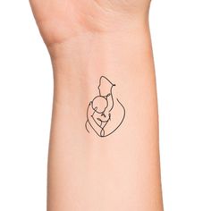 a woman's wrist with a small tattoo of a man holding a baby in his arms